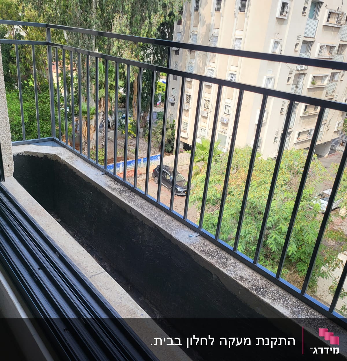 מעקה מתכת שחור במרפסת עם אדנית ריקה